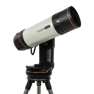 Dieses Bild zeigt das Celestron Origin Intelligent Home Observatory in einer azimutalen Konfiguration. Hier ist die passende Beschreibung für den Alt-Text: Gerät: Das Celestron Origin, ein voll integriertes, intelligentes Teleskopsystem für die Astrofotografie. Aufbau: Im Gegensatz zum vorherigen Bild ist das Teleskop hier ohne die Polhöhenwiege (Wedge) direkt auf dem Stativ montiert. Es handelt sich um eine azimutale Gabelmontierung, bei der sich das Teleskop in der Höhe (vertikal) und im Azimut (horizontal) bewegt. Optik: Das helle, zylindrische Rohr ist ein 6-Zoll Rowe-Ackermann Schmidt Astrograph (RASA). Das optische Design ist für extrem schnelle Aufnahmen (kurze Belichtungszeiten) von Deep-Sky-Objekten wie Nebeln und Galaxien optimiert. Design: Das Gerät ist in einem modernen Schwarz-Weiß-Design gehalten, akzentuiert durch die für Celestron typischen orangefarbenen Ringe am Tubus und an der Basis. Am Tubus ist deutlich der Schriftzug „CELESTRON“ sowie das „Origin“-Logo zu erkennen. Funktionsweise: Es handelt sich um ein computergesteuertes System, das die Ausrichtung, Nachführung und Bildbearbeitung (Stacking) automatisch übernimmt und die Ergebnisse drahtlos an mobile Endgeräte überträgt. Möchten Sie mehr über die technischen Unterschiede zwischen der azimutalen und der parallaktischen Aufstellung erfahren?